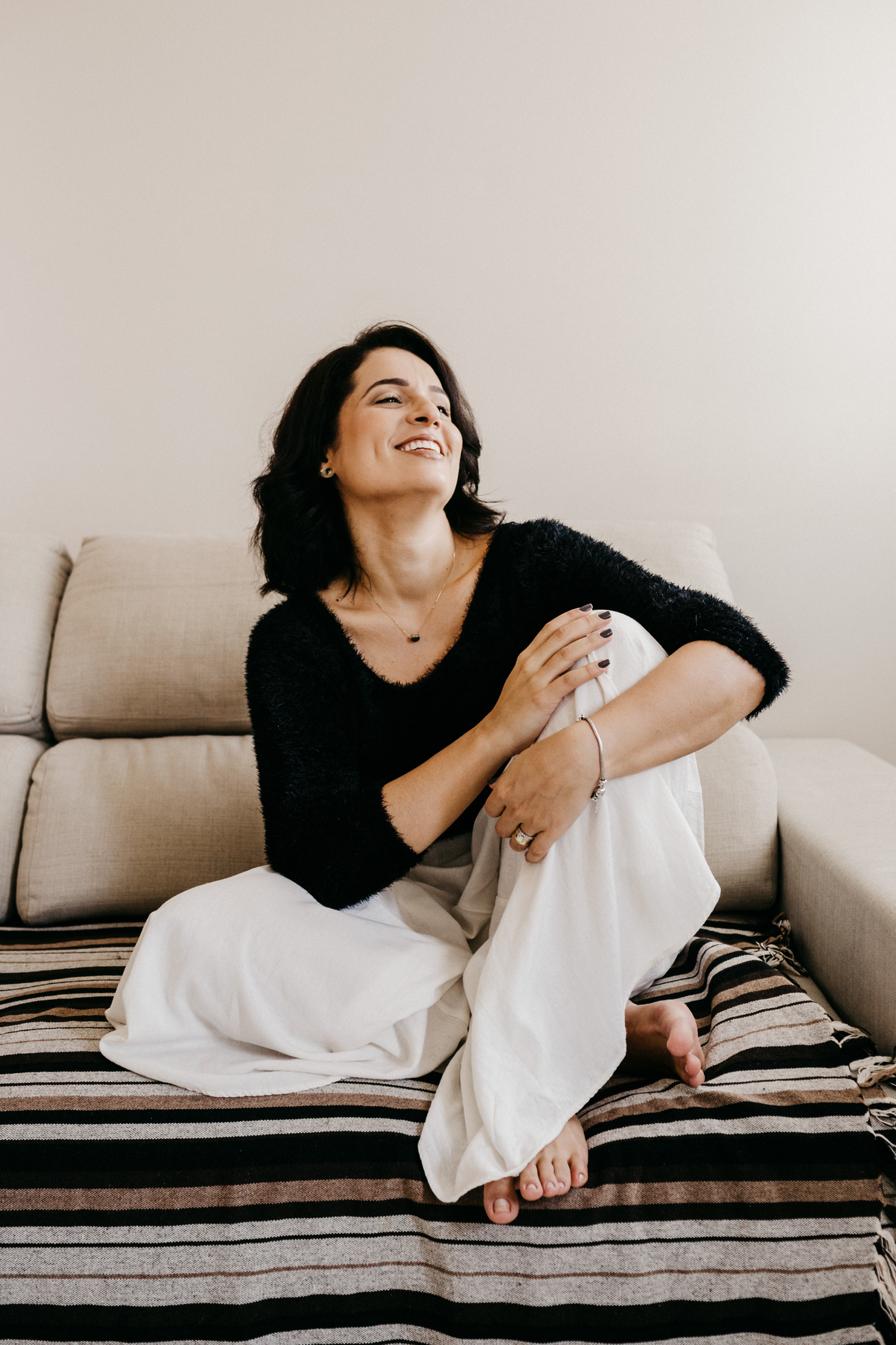 Stylish happy woman resting on sofa in flat